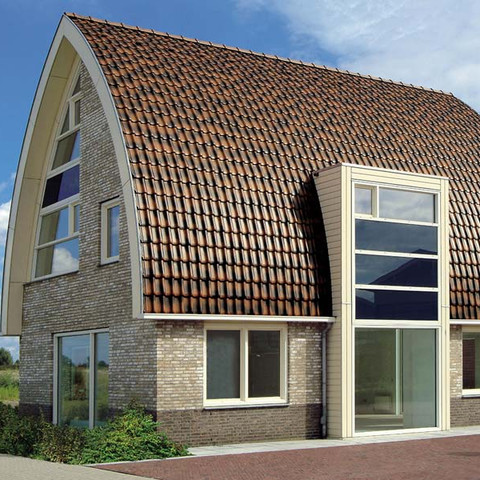 A single-family house covered with shaded copper brown Flandern tiles