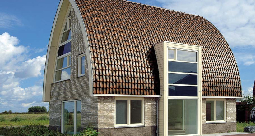A single-family house covered with shaded copper brown Flandern tiles